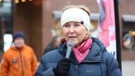 Kaisa Juuso tummansinisessä toppatakissa puhuu mikrofoniin ulkona.