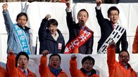 Japanin pääministeri Sanae Takaichi puoluetovereineen tervehtii yleisöä vaalitilaisuudessa nyrkkiin puristettu käsi ilmassa.