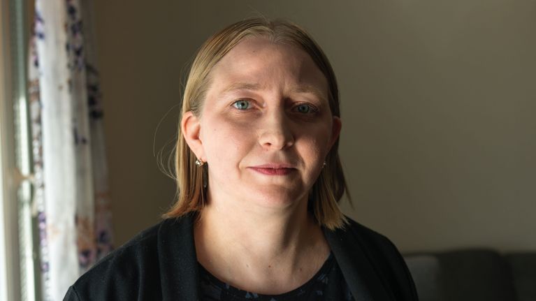 Nainen on kameraan päin, mutta katsoo hieman ohi kameran vasemmalle puolelle.