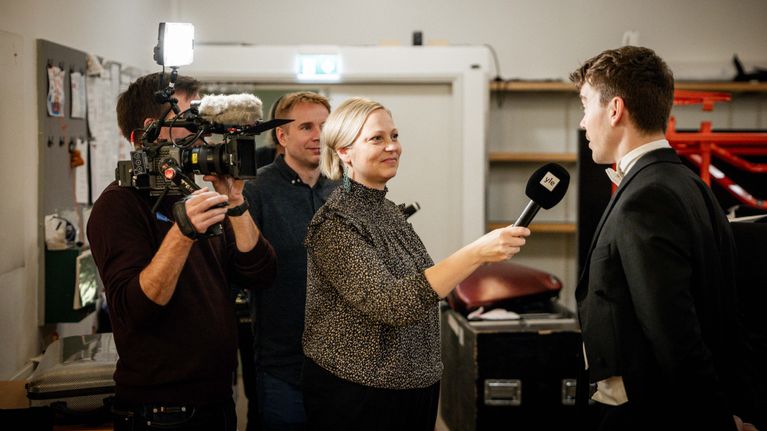 Ylen toimittaja Noora Hirn haastattelee sellisti Antto Tunkkaria. Kuvassa myös kuvaaja Juha Tuominen ja ohjaaja Ilmari Aho.