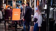 Miehet katselevat vaatekaupassa alennuksessa olevia tuotteita.