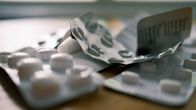 Halvöppna medicinkartor ligger på ett bord.