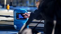 A person is touching the payment machine on a bus. 