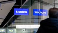 Henkilö kävelee Nordean pankin ikkunoiden ohi.