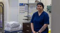Roosa Pynttäri istuu pyykkikorin päällä pesulassa.