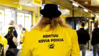 SaiPan kannattaja seisoo selkä kameraan päin. Hänellä on yllään keltainen takki, jonka selässä lukee "KOHTUU KOVIA POIKIA".