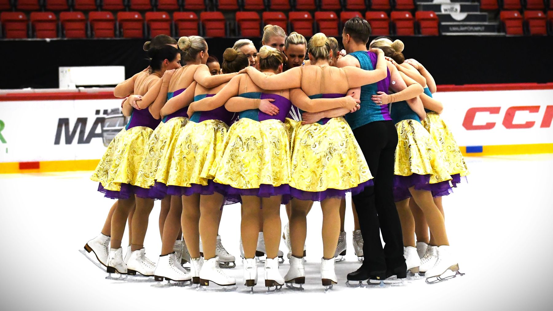 Synkrolaget Team Antique står tillsammans i en ring på isen.