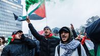 Miehet heiluttavat Palestiinan lippua mielenosoituksessa.