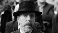 Gunther von Hagens sisätiloissa tumma hattu päässä ja puku yllään. 