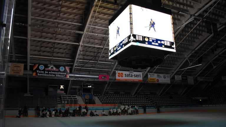 Rauman jäähallin mediakuutiossa esitellään Rauman Lukon pelaajia, pimeässä hallissa.