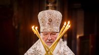 Patriarkka Kirill seisoo kynttilöiden takana.
