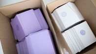Kaksi pahvilaatikkoa, joista toisessa violetteja ja toisessa valkoisia äänestyslippuja.