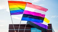 Tre flaggor: Prideflaggan, flagga för ickebinära och flagga för genderfluida personer.
