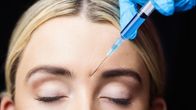 Kvinna får botox i pannan.