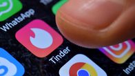 Sormi puhelimen näytöllä painamassa Tinder -deittisovelluksen tunnusta.