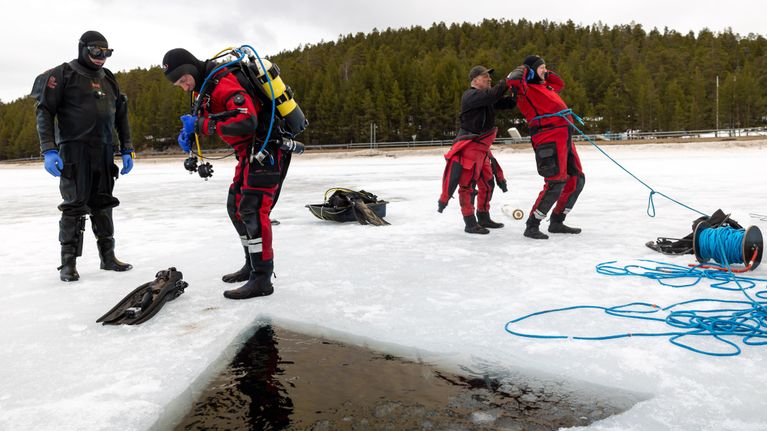 Sukeltajat valmistautuvat sukeltamaan avantoon Inarin Myössäjärvellä.