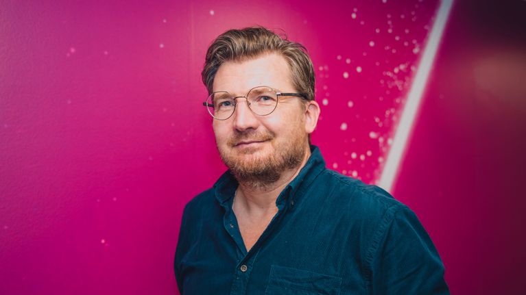 Uuuden Musiikin Kilpailun tuottaja Anssi Autio UMK-seinän edessä.