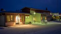 Lumijoen terveyskeskus aamulla. Etualalla pihavalaismia ja polkupyörä.