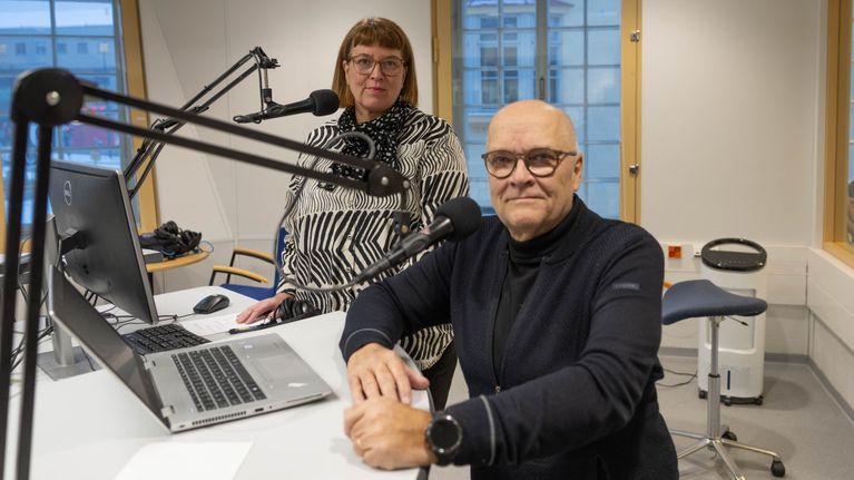 Mikaela Nylander och Jorma Wiitakorpi i Yle Östnylands studio. I bilden syns mikrofoner och fönster.