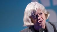 Ann Widdecombe ruudullisessa jakussa puhuu mikrofoniin.