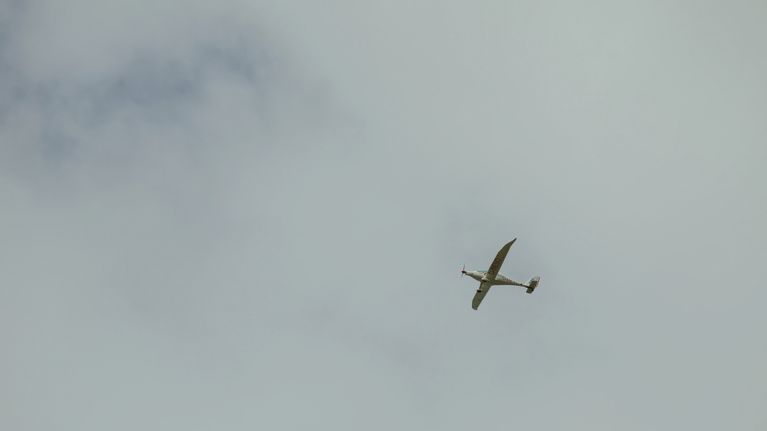 A small airplane flies overhead.