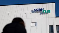Varhan logo sairaalan seinässä. Etualalla ihmishahmo.