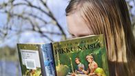 Tyttö lukee kirjaa Pikku naisia