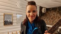 Erja Lyytinen med gitarr, i bakgrunden hennes pristavla för bästa europeiska bluesgitarrist