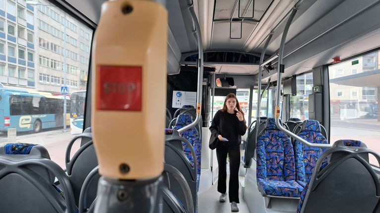 Nuori nainen astuu linja-autoon sisään