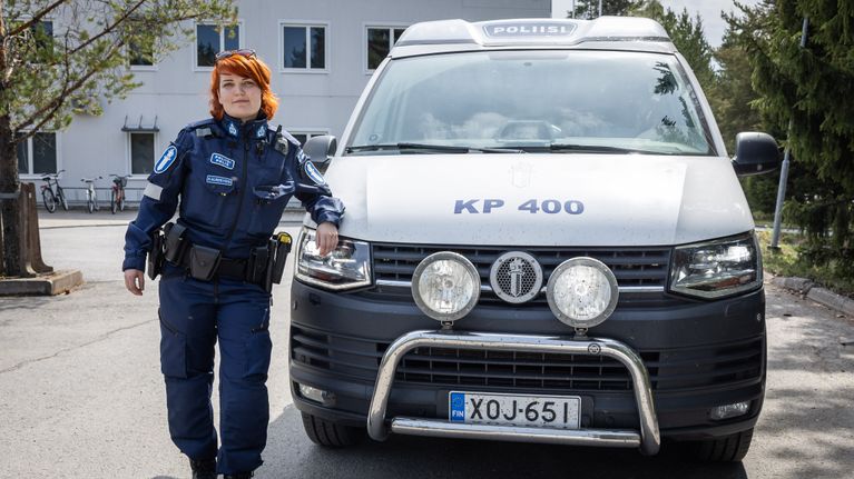 Poliisi nojaa polisiiautoon.