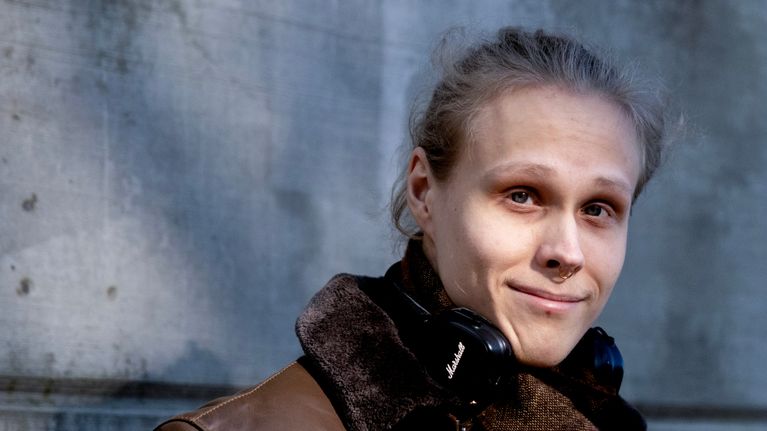 Kim Jalonen nahkatakki päällään ja kuulokkeet kaulassa katsoo kameraan.