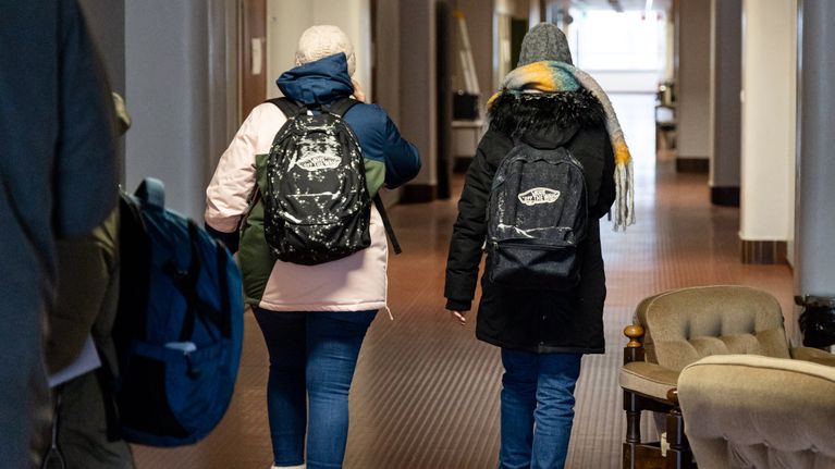 Kaksi vaihto-opiskelijaa kävelevät Raakunamäen vanhan varusmiesten majoituskasarmin käytävää pitkin.