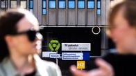 Henkilöitä istuu TE-palvelu toimisto luona ulkona.