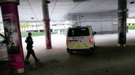 Poliisi kävelee sillan alla poliisiautojen vieressä.