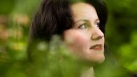 Laura Sgureva-Cox luonnossa katsoo oikealle ylös.