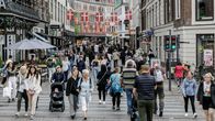 Vilkas kävelykatu, jolla kävelee ja seisoskelee ihmisiä.
