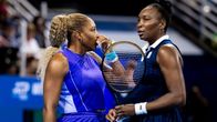 Serena ja Venus Williams keskustelevat tenniskentällä nelinpeliottelussa.