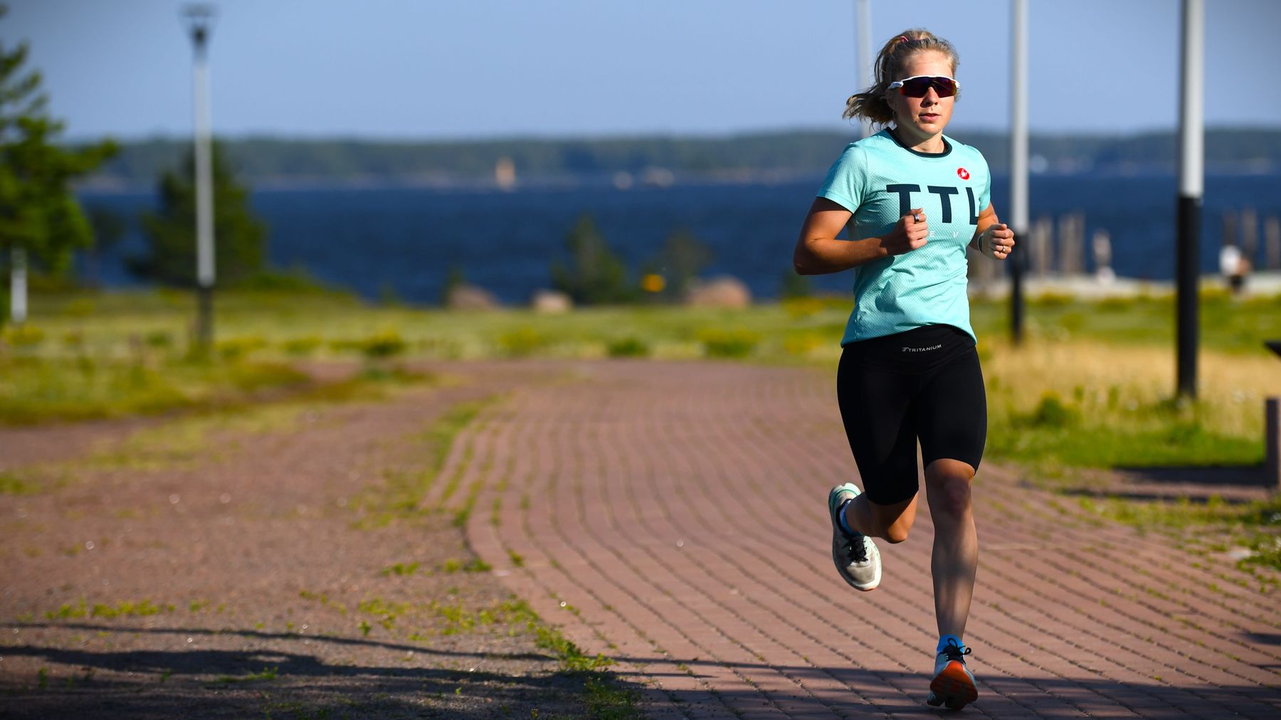 Triathleten Minttu Hukka löptränar i park.