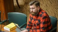 Perussuomalaisten kansanedustaja Sebastian Tynkkynen istumassa omalla paikallaan eduskunnan istuntosalissa.