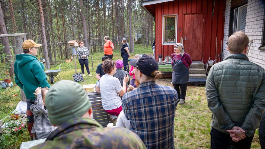 Ihmisiä kokoontuneina talon pihalle. Irja Jefremoff kertoo petun keruun teoriasta kurssilaisille. 