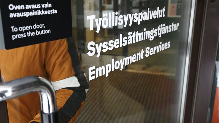 Henkilö poistumassa tilassa jonka ovessa lukee työllisyyspalvelut.