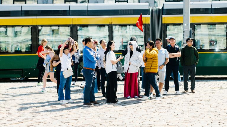 Photo shows a group of tourists in Helsinki.