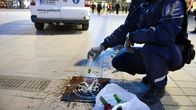 Poliisi kaataa nuorilta takavarikoituja alkoholijuomia viemäriin Narinkkatorilla Helsingissä.