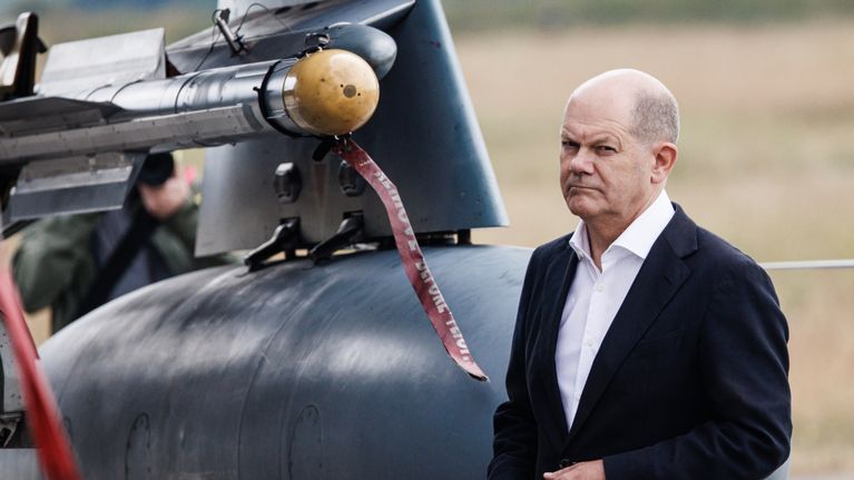 Olaf Scholz seisoo ohjuksen vieressä.