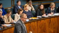 Keskustan puheenjohtaja kansanedustaja Antti Kaikkonen puhumassa vanhuslaista eduskunnan suuressa salissa puhujapöntössä. Taustalla ministereitä.
