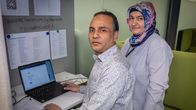 Md. Nurul Hague Chowdhury istuu tietokoneen äärellä,  Emine Neval neuvoo.