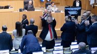 Israelin turvallisuusministeri kohottaa kuohuviinipulloa ja hymyilee, kun palestiinalaisten kuolemantuomiolakiesitys meni julki.