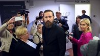 Mustiin pukeutunut laulaja Lauri Tähkä asianajajansa ja median ympäröimänä oikeustalon aulassa.
