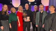 En grupp personer som står tillsammans i en studio.