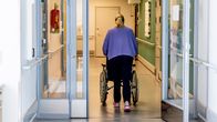 Hoita työntää rullatuolia palveluasumisen hoitoyksikössä.